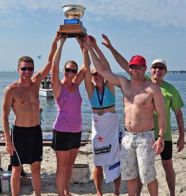 swimmers holding up award at finish line