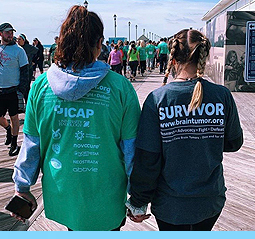 Image of two survivors, hand in hand, walking at a New Jersey event.