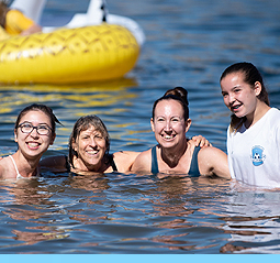 An image of participants smiling in the water.