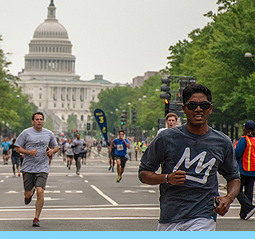 Image of two runners sprinting towards the finish line with the US capitol building behind them.