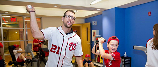 Washington Nationals player plays video game with a young boy