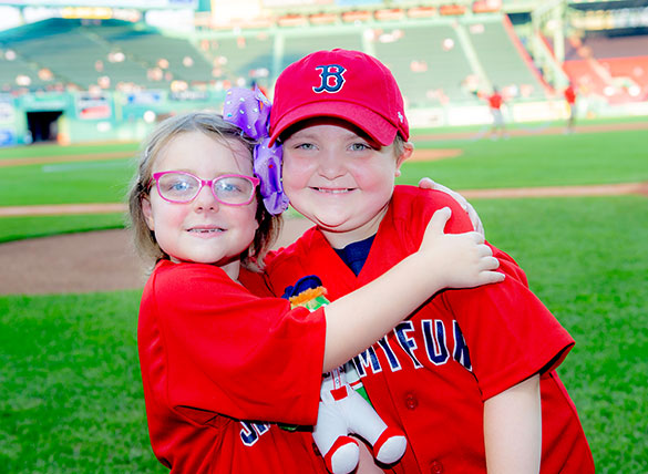 Two Jimmy Fund Clinic patient friends hug at Fenway Park during the 2021 Jimmy Fund Radio-Telethon