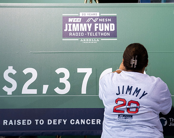 A volunteer updates the board for the amount raised at the Jimmy Fund Radio-Telethon