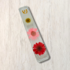 Clear epoxy resin mezuzah cover with three colours of dried daisies