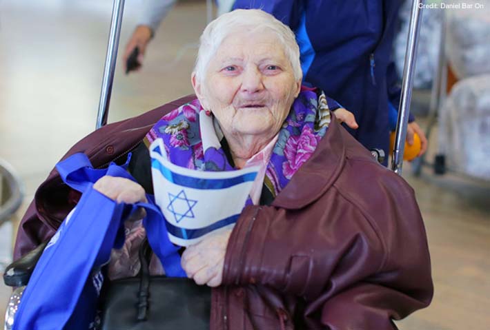 Aliyah, elderly woman in floral scarf