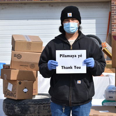 A COVID Emergency Delivery recipient with a thank you sign