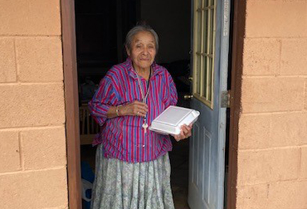 An Elder receiving her Thanksgiving dinner at home